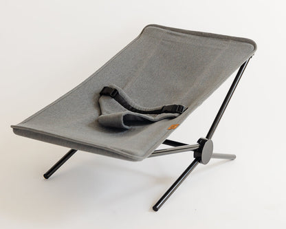 Gray folding chair with black legs on a white background
